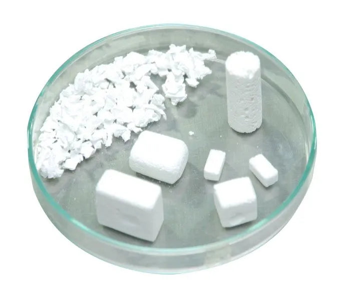 Various shapes of synthetic bone graft material for dental implants displayed on a glass petri dish