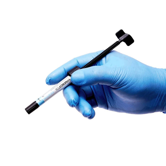 Hand wearing blue gloves holding a Coltene Synergy Composite Syringe by Beetle Dental on white background