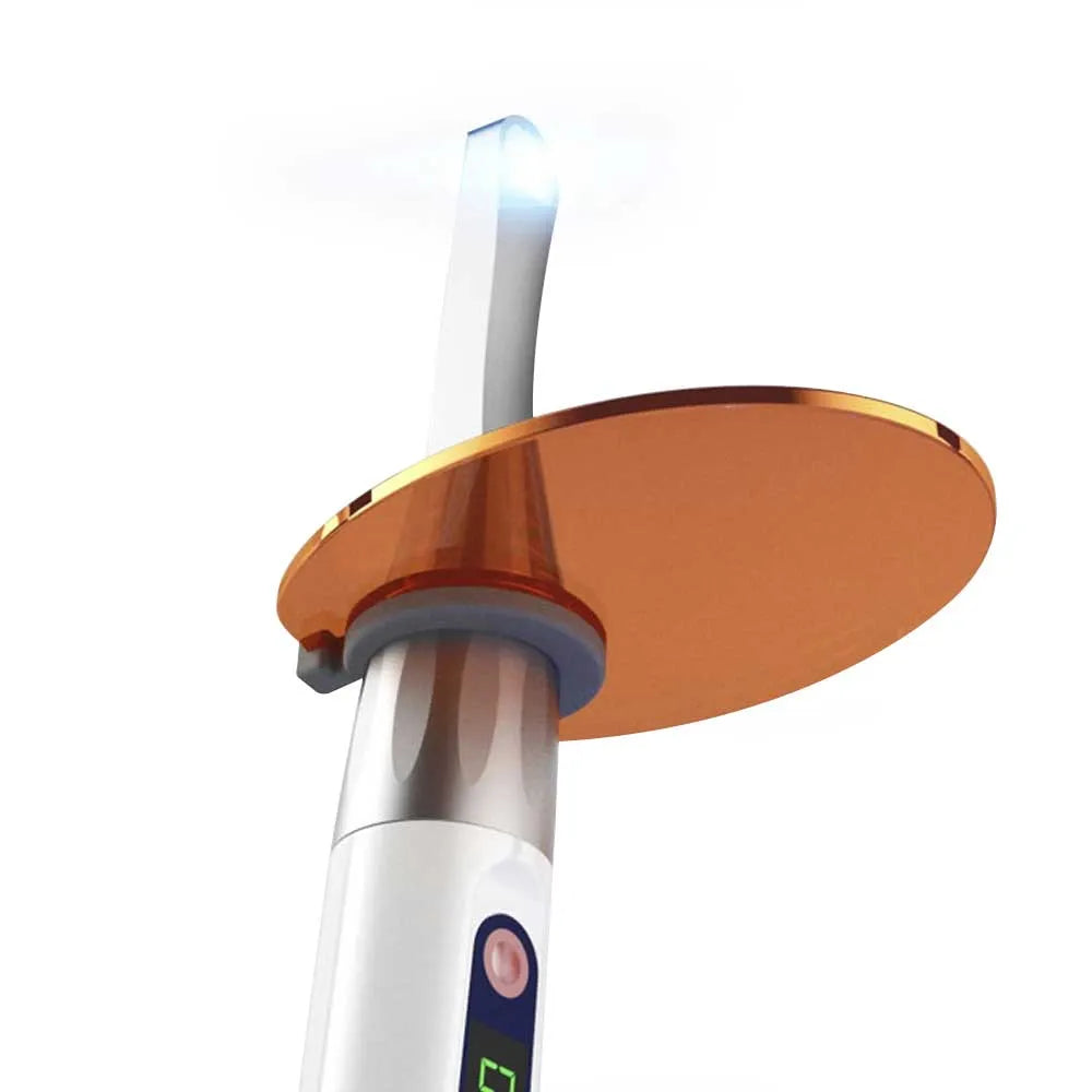 Beetle Dental Woodpecker ILED Plus curing light white handpiece with orange protective shield and glowing tip