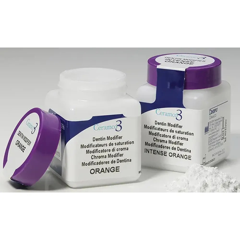 Two jars of Dentsply Ceramco 3 dentin modifier powder in orange and intense orange with spilled powder