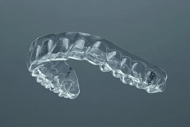 Clear dental aligner tray on gray background showing tooth impressions Beetle Dental Scheu CA Pro dental aligner sheets.