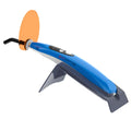 Woodpecker LED D curing light blue cordless dental curing wand with orange shield on gray charging stand