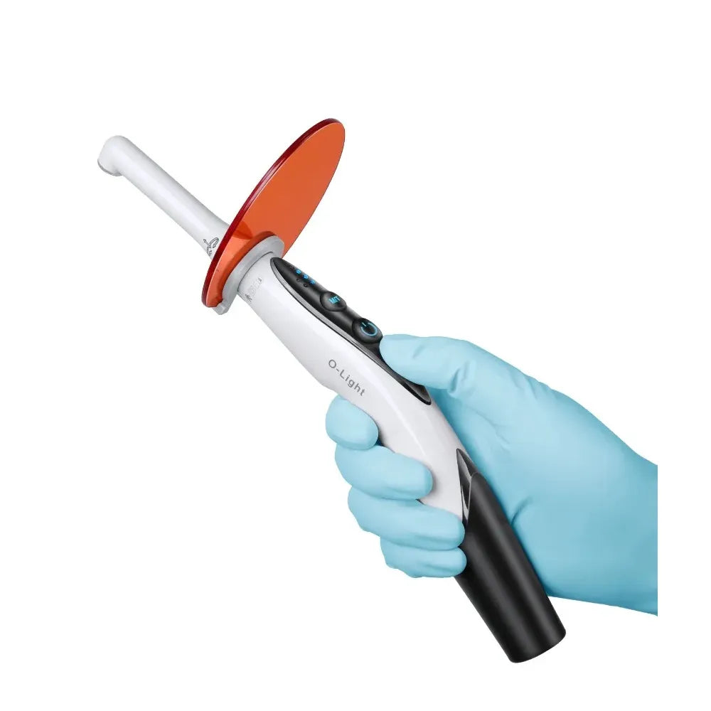 Beetle Dental handheld curing light with orange shield held by gloved hand Woodpecker LED light cure probes for dental bonding